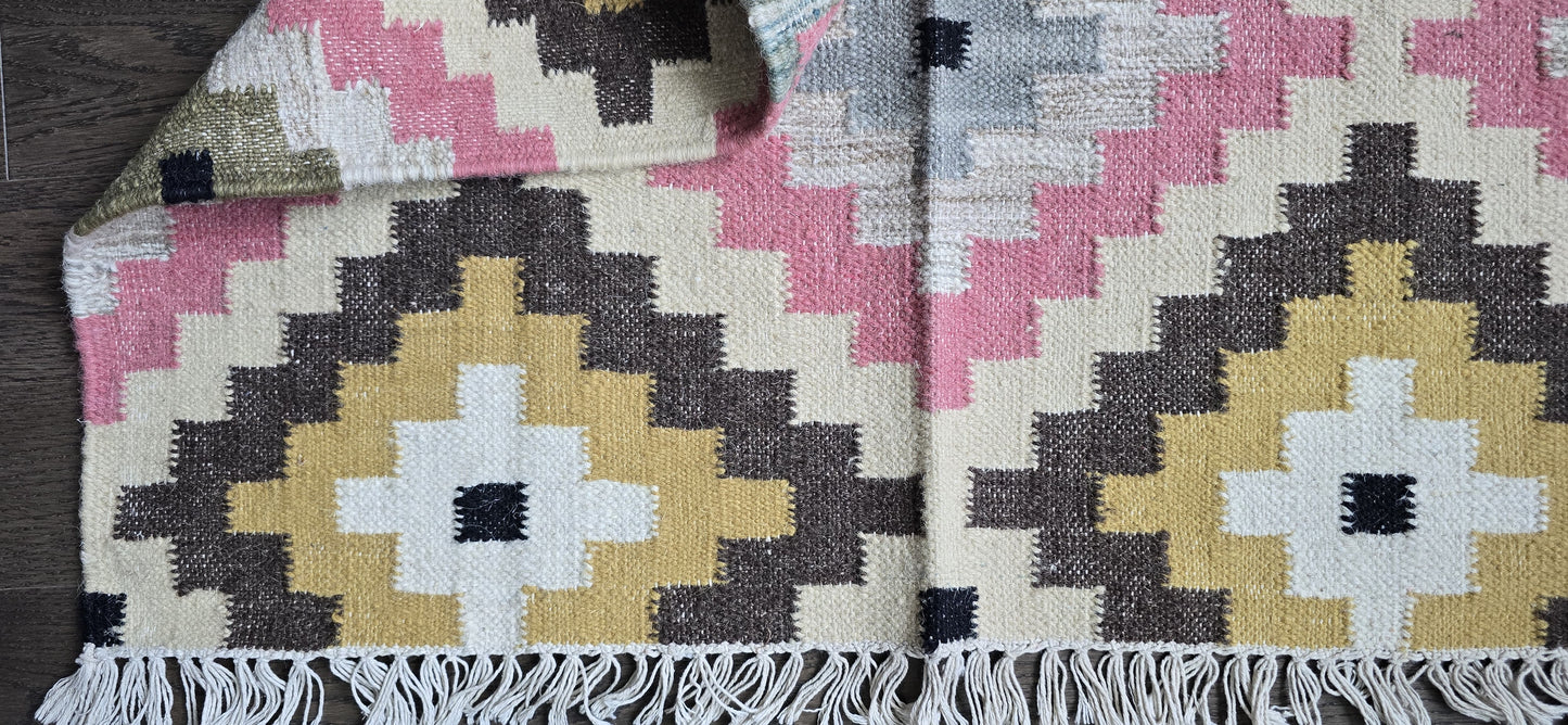 Woven textile with geometric pattern on a wooden surface