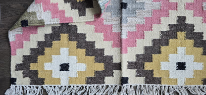 Woven textile with geometric pattern on a wooden surface