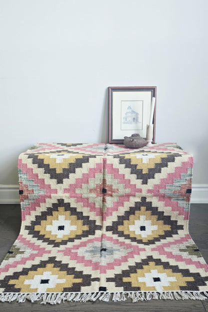 Patterned rug on a wooden floor with a framed picture in the background